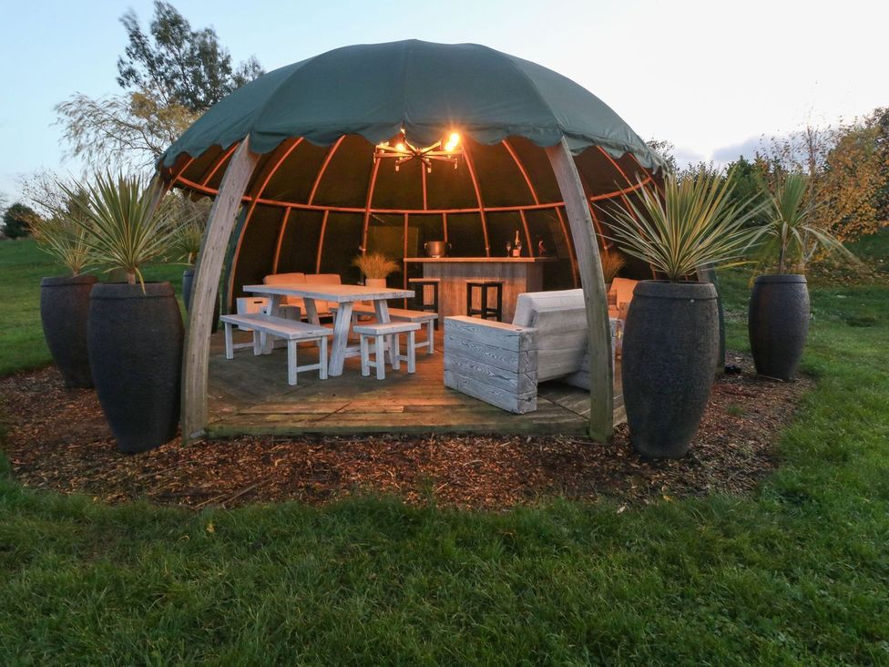 An outdoor gazebo with seating and a bar at Poppie's Shepherds Hut at Shepherds Lodge Retreat and Wellness Nottingham