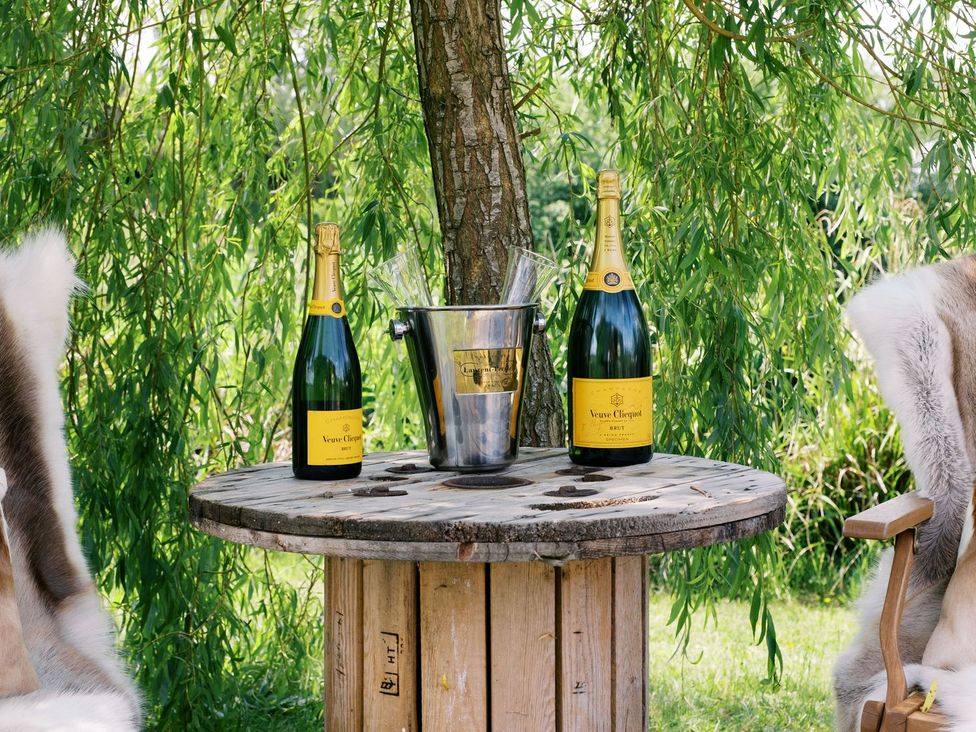 A table with champagne and an ice bucket in an outdoor area at Poppie's Shepherds Hut at Shepherds Lodge Retreat and Wellness, Nottingham