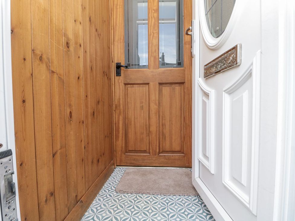 A hallway with wooden paneling and a front door at Chapel Cottage in Filey