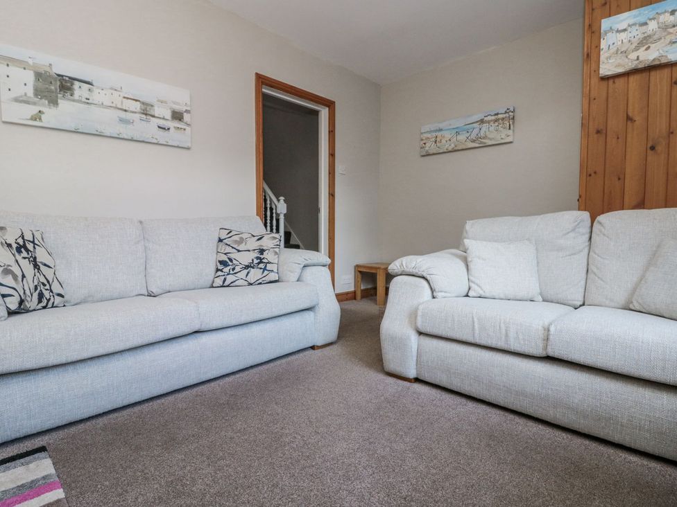 A living room with sofas and a staircase at Chapel Cottage in Filey