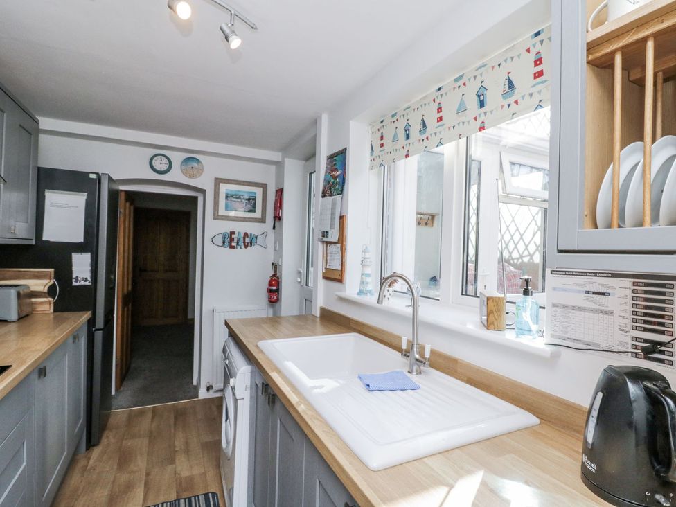 A kitchen with a sink and fridge at Chapel Cottage in Filey