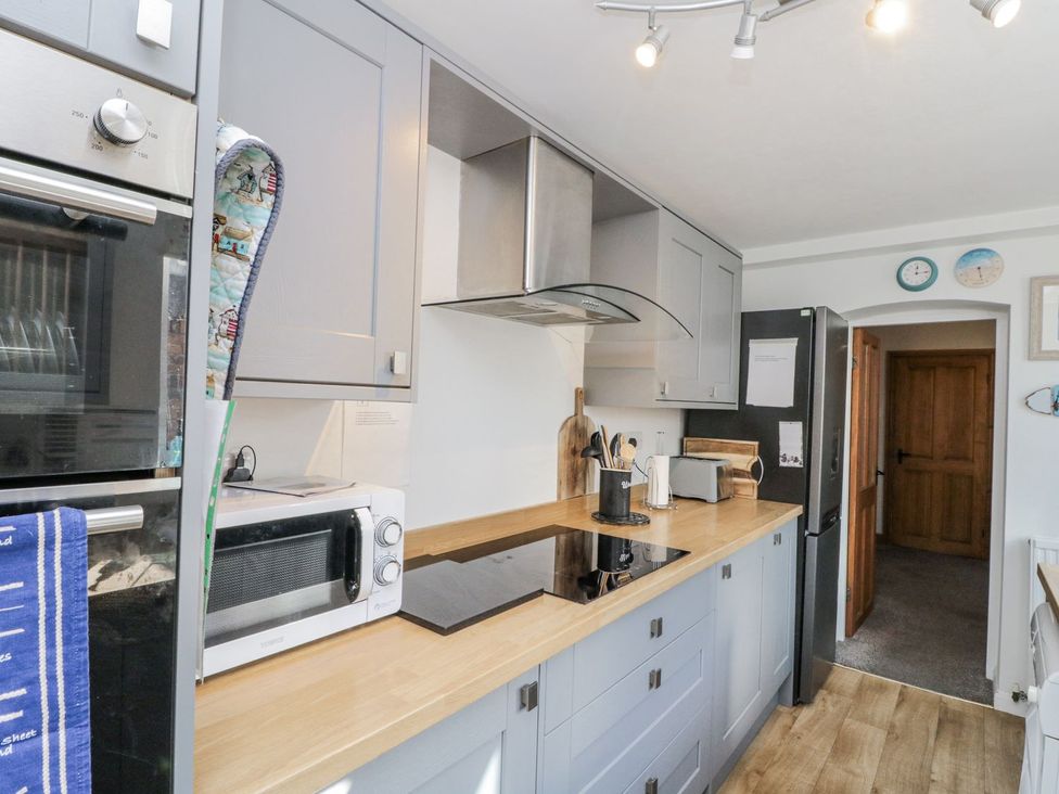 A kitchen with appliances and wooden countertop at Chapel Cottage in Filey
