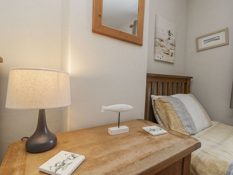 A bedroom with a bedside table and lamp at Chapel Cottage in Filey