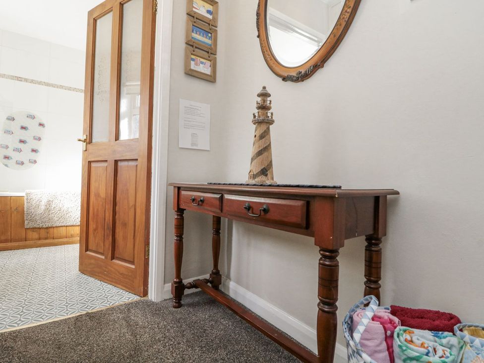 A hallway with a console table and a mirror at Chapel Cottage in Filey