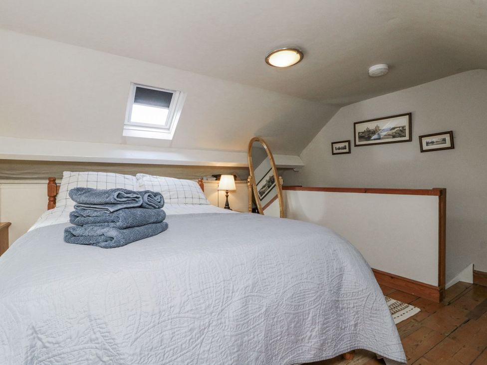 A bedroom with a bed and a lamp at Chapel Cottage in Filey