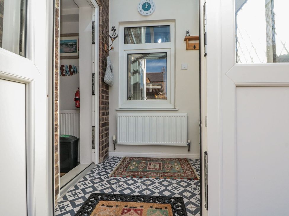 A hallway with a door and window at Chapel Cottage in Filey