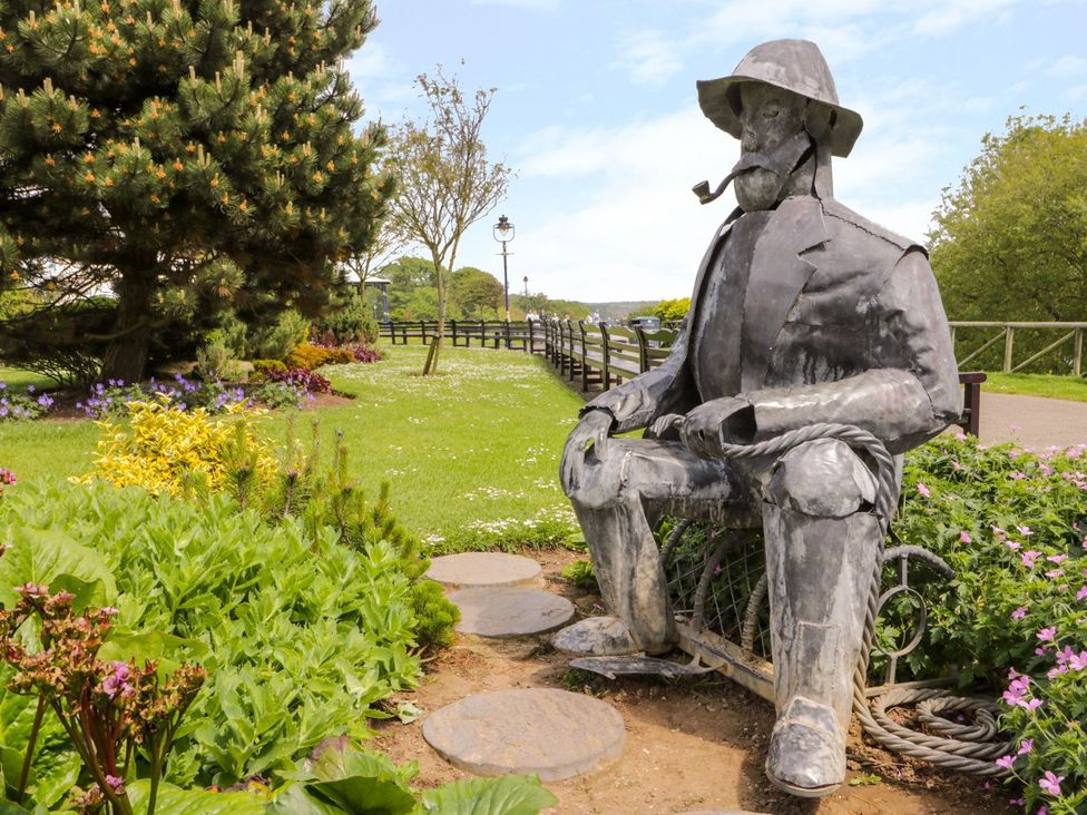 A statue in a garden with flowers at Chapel Cottage in Filey