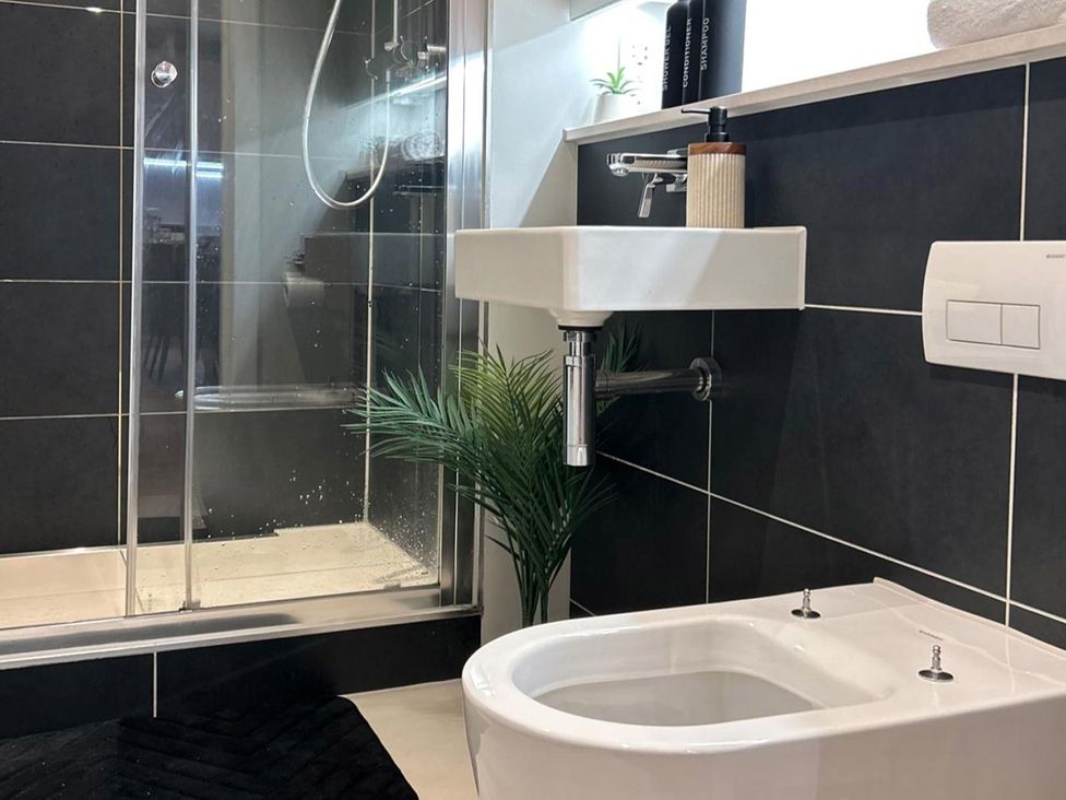 A bathroom with a shower, sink, bidet, and plant at Central Apartment with Free Parking, Terrace and Gym in Manchester
