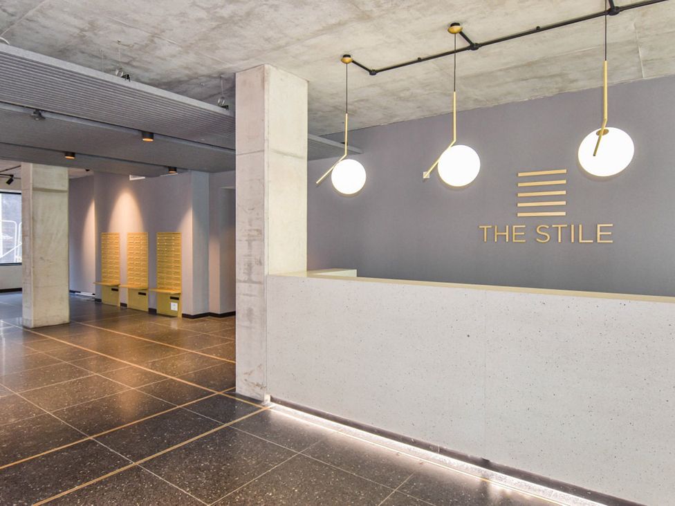 A lobby with a reception desk and mailboxes at The Stile in Manchester