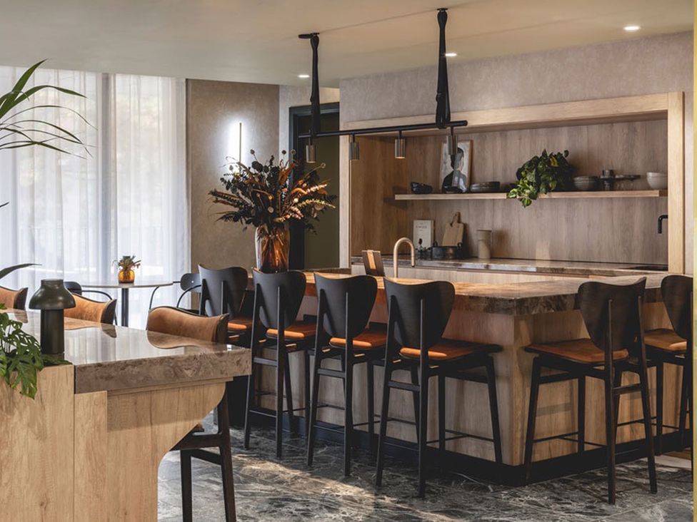 A kitchen with bar stools and a kitchen island at Central Apartment with Free Parking, Terrace and Gym in Manchester