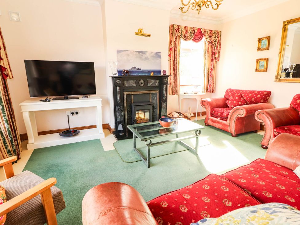 A living room with a television and a fireplace at Cross Beg in Kilmihil, County Clare