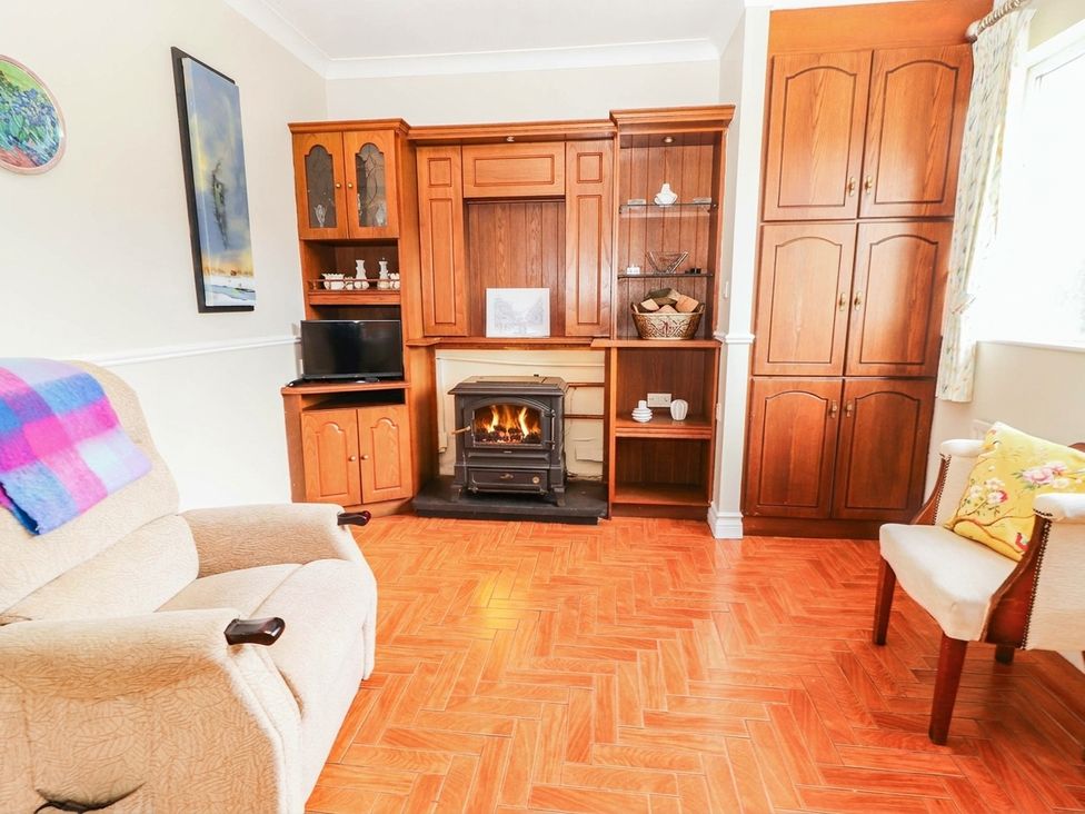 A living room with a fireplace and television at Cross Beg in Kilmihil, County Clare