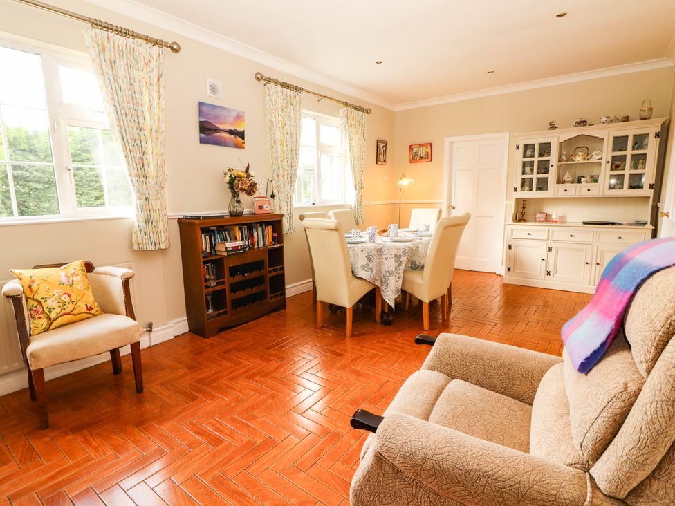 A living room with a dining area and bookshelf at Cross Beg in Kilmihil, County Clare