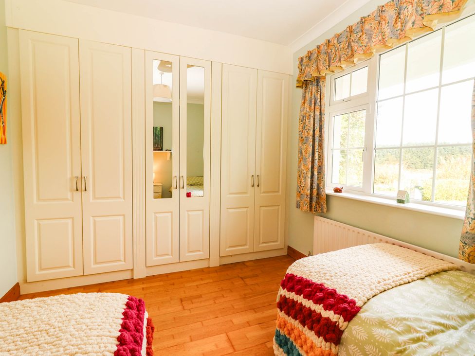 A bedroom with a wardrobe and two beds at Cross Beg Kilmihil, County Clare