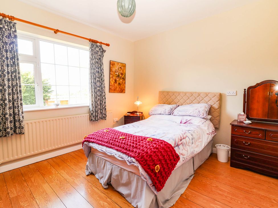 A bedroom with a bed and nightstand at Cross Beg, Kilmihil, County Clare