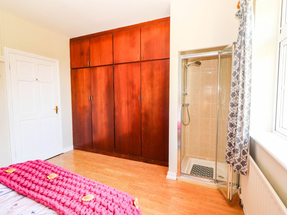 A bedroom with a wardrobe and shower at Cross Beg, Kilmihil, County Clare