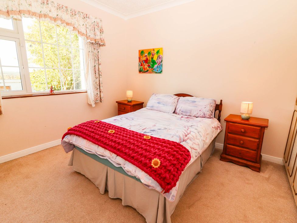 A bedroom with a bed and two nightstands at Cross Beg Kilmihil, County Clare