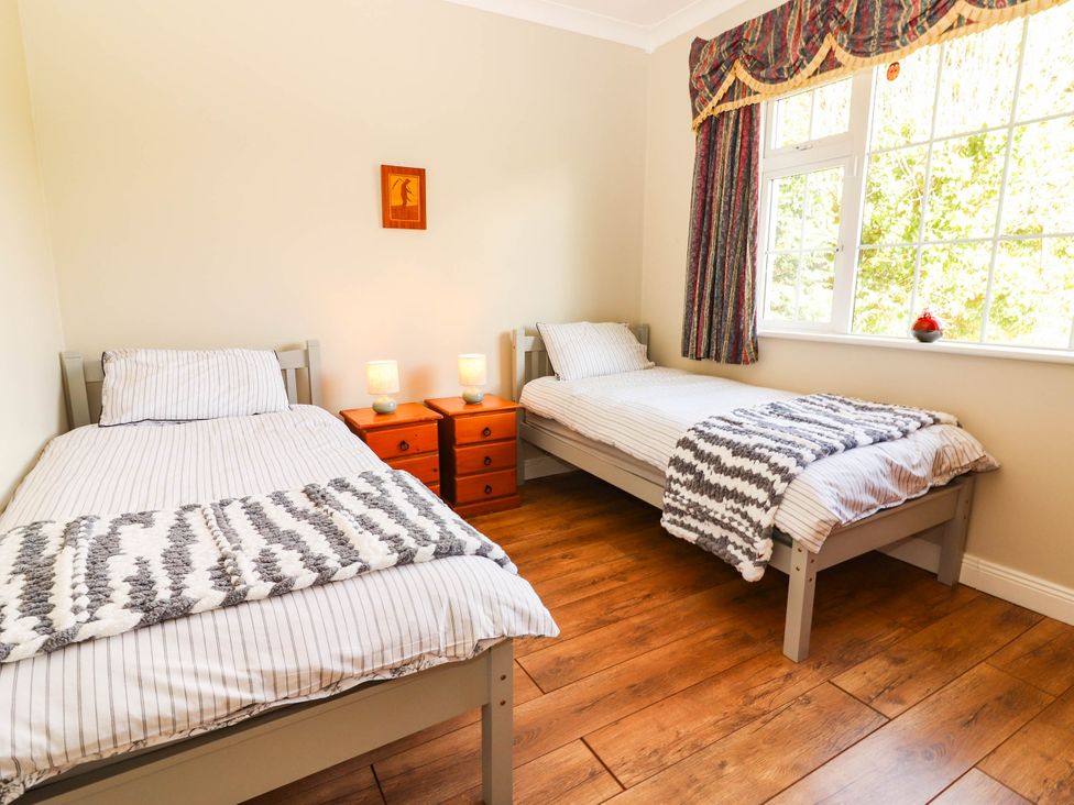 A bedroom with two single beds and a window at Cross Beg, Kilmihil, County Clare