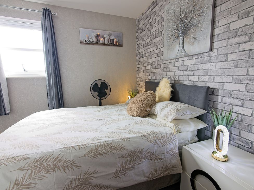 A bedroom with a bed and fan at 2 Bedroom Apartment in Manchester