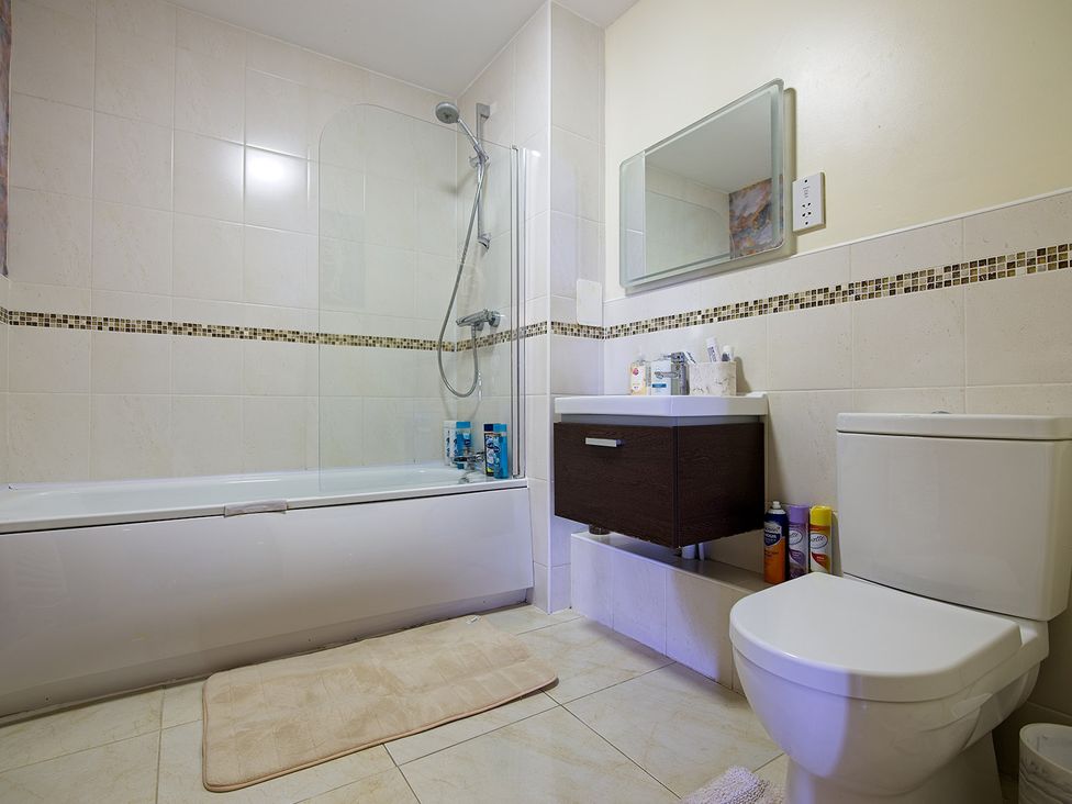 A bathroom with a bathtub and shower at 2 Bedroom Apartment in Manchester