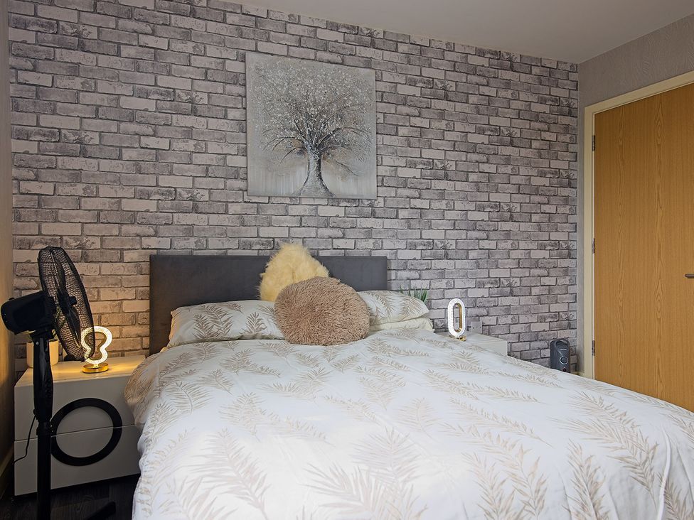 A bedroom with a bed and wall art at 2 Bedroom Apartment in Manchester