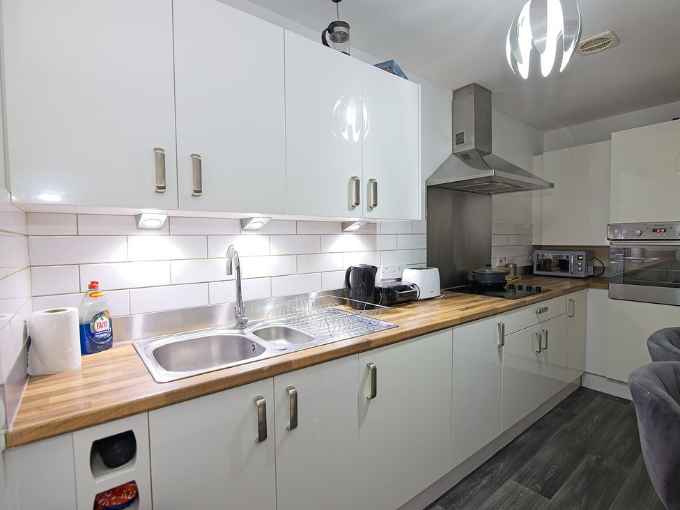 A kitchen with sink and appliances at 2 Bedroom Apartment in Manchester