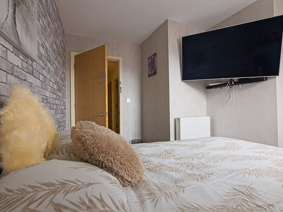 A bedroom with a bed and television at 2 Bedroom Apartment in Manchester