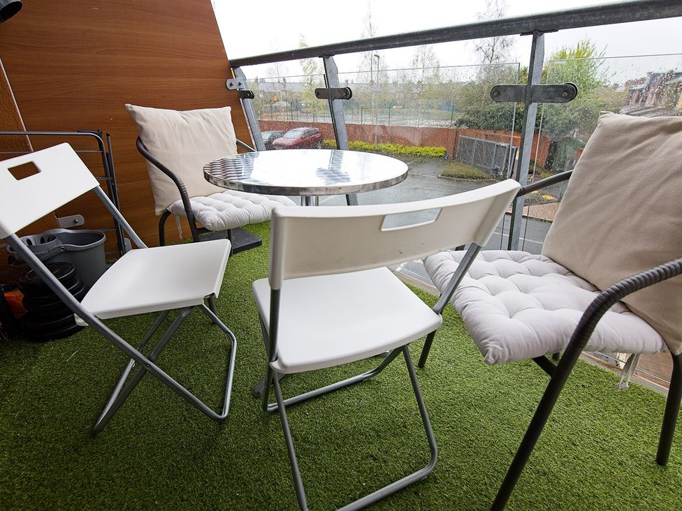 A balcony with seating and a table at 2 Bedroom Apartment in Manchester