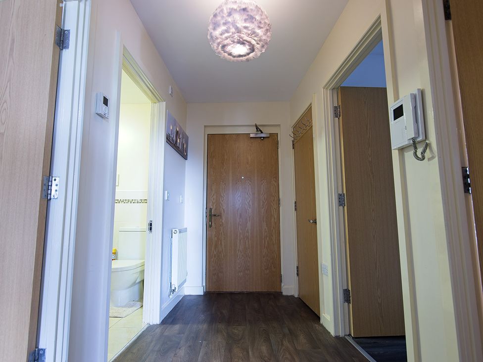 A hallway with doors leading to rooms at 2 Bedroom Apartment in Manchester
