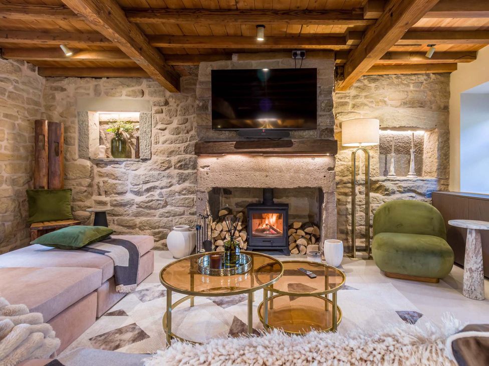 A living room with a fireplace and sofa at Heaven Lea Cottage