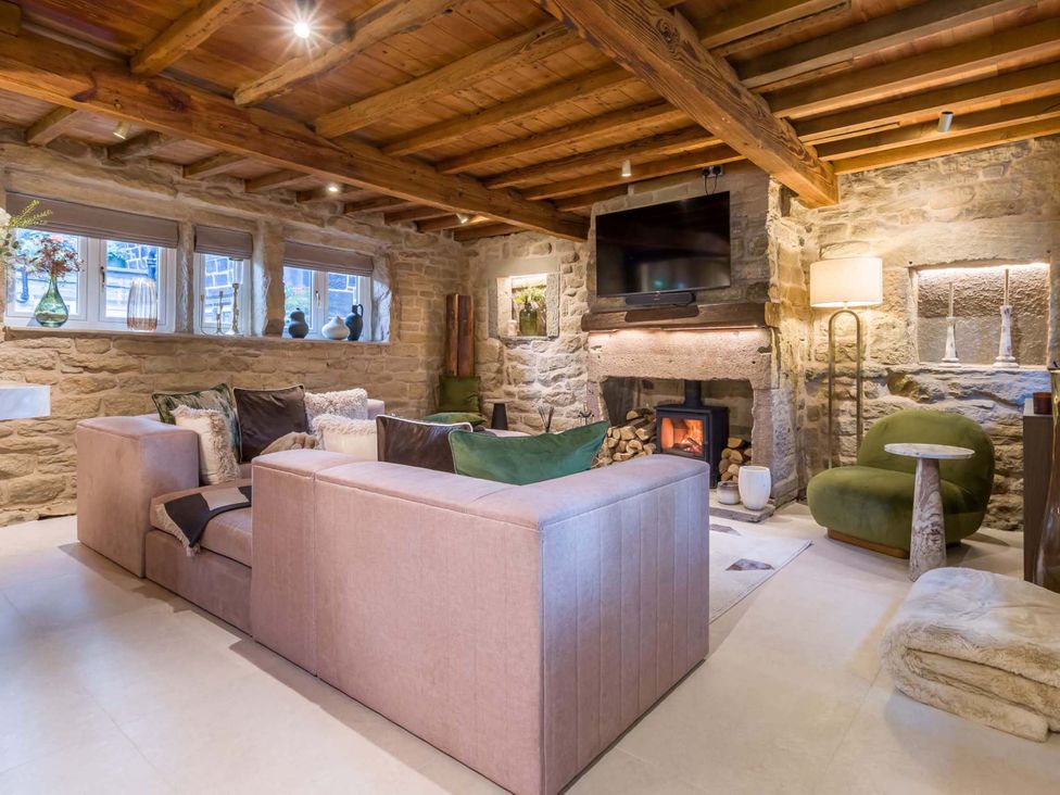 A living room with sofas and a fireplace at Heaven Lea Cottage