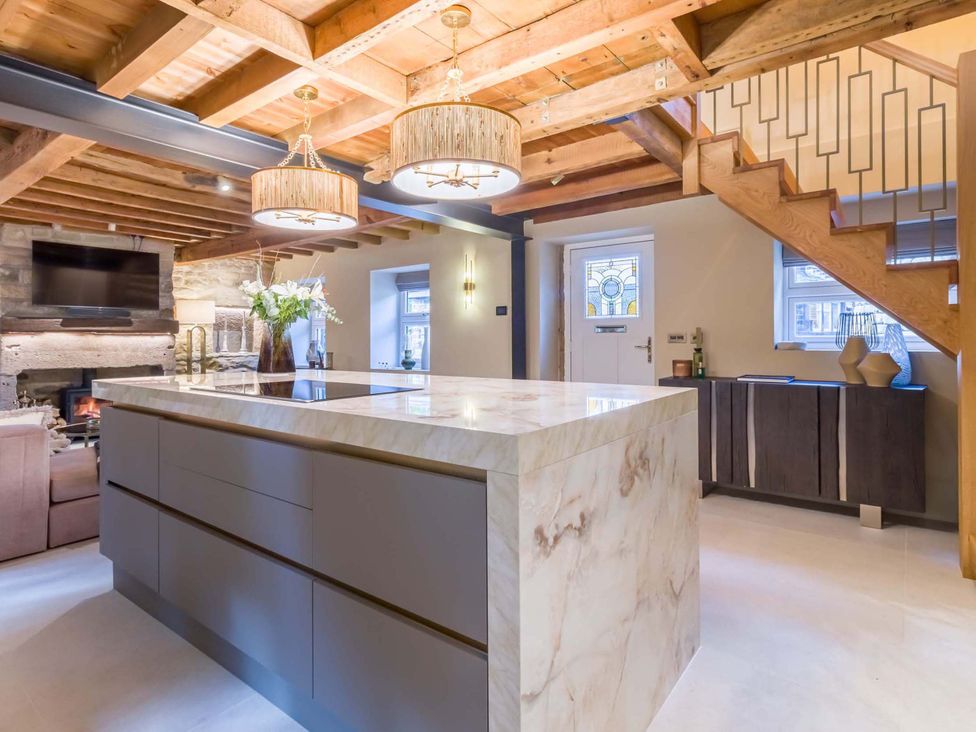 A kitchen with an island and television at Heaven Lea Cottage