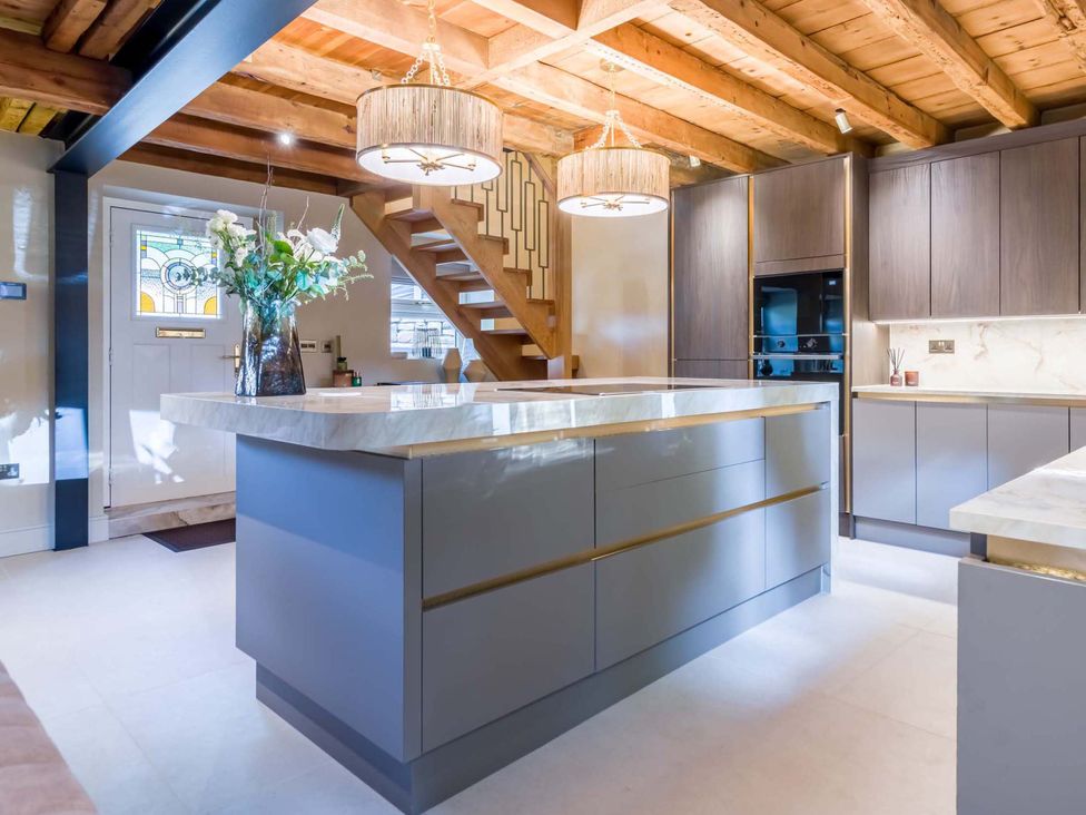 A kitchen with an island and cabinets at Heaven Lea Cottage