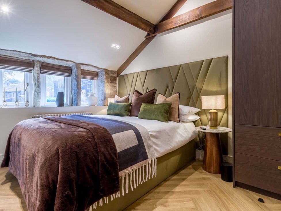 A bedroom with a bed and bedside table at Heaven Lea Cottage