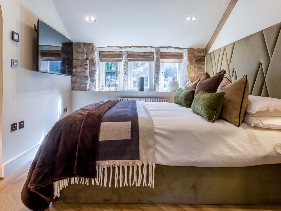 A bedroom with a bed and television at Heaven Lea Cottage