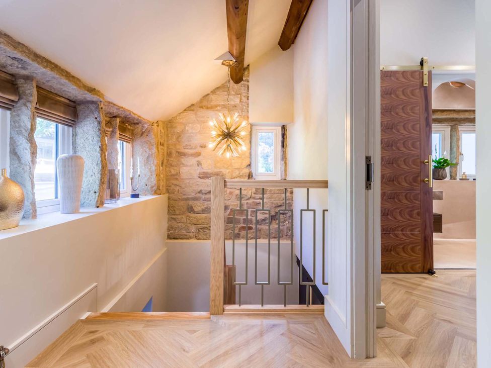 A hallway with windows and decorative vases at Heaven Lea Cottage 