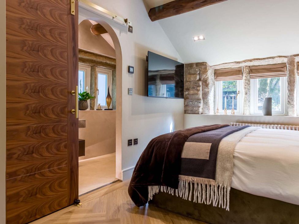 A bedroom with a bed and television at Heaven Lea Cottage