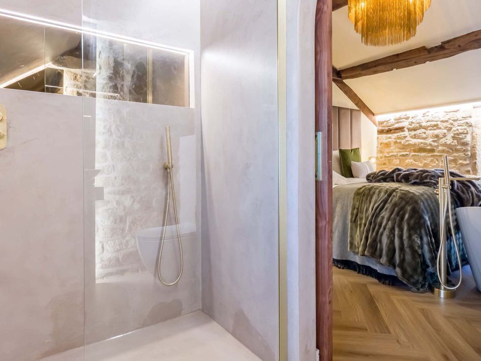 A bathroom with a shower and a view of the bedroom at Heaven Lea Cottage