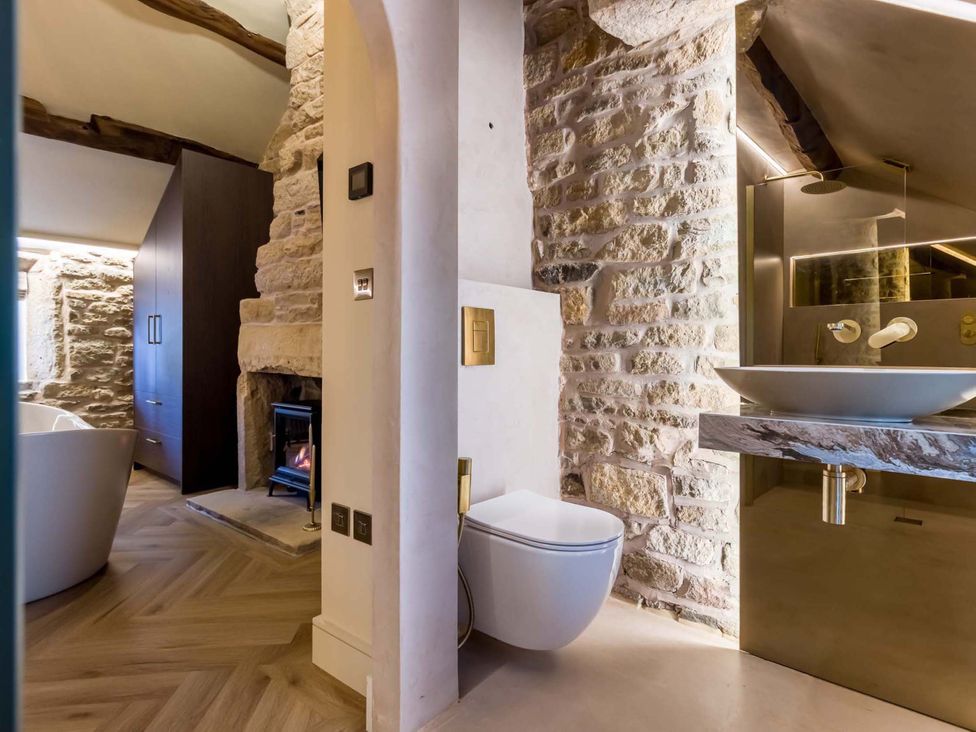 A bathroom with a bathtub, toilet, and sink at Heaven Lea Cottage