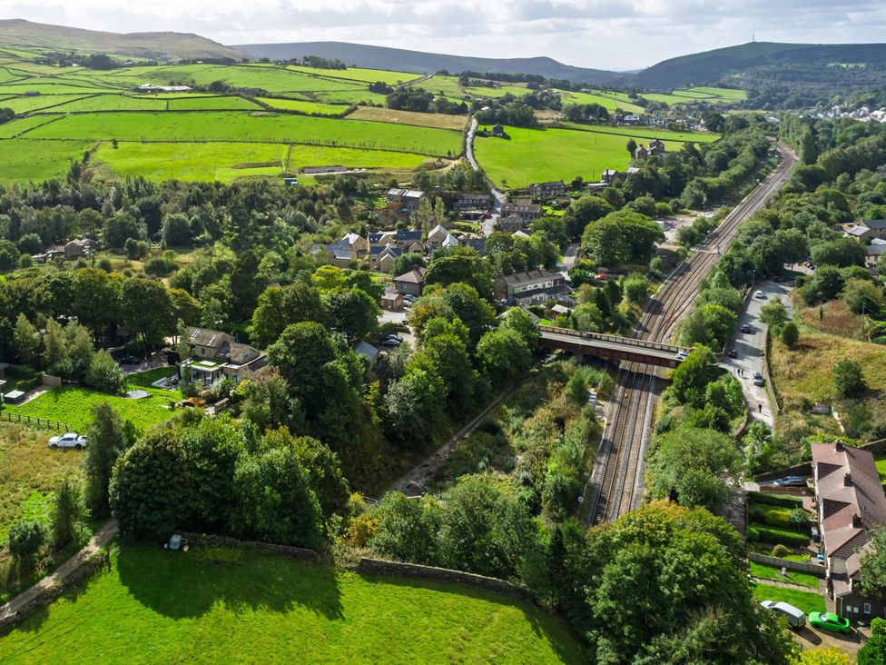An aerial view of a village with fields and a railway at Heaven Lea Cottage