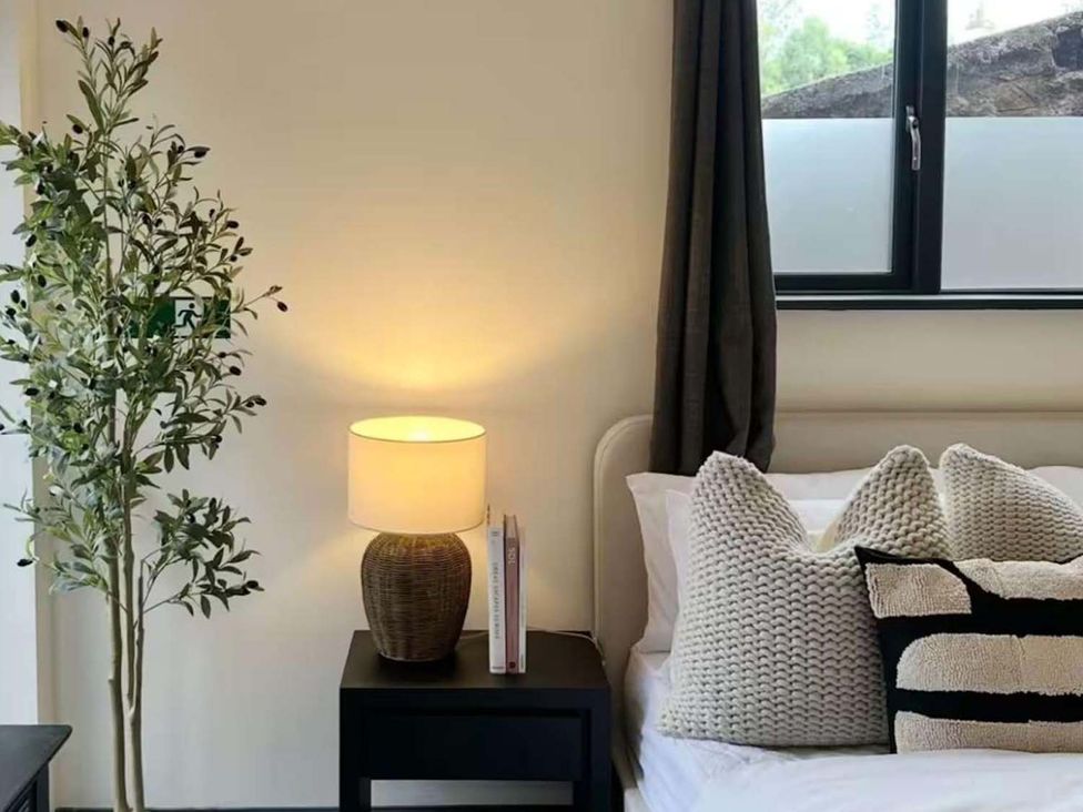 A bedroom with a bed, bedside table and lamp at New Cosy Retreat in Matlock Bath