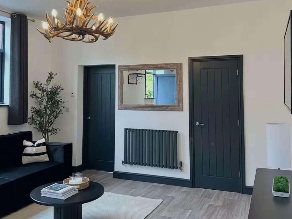 A living room with a chandelier and a plant at New Cosy Retreat in Matlock Bath