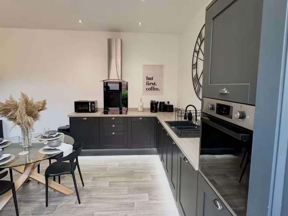 A kitchen with an oven and microwave at New Cosy Retreat in Matlock Bath