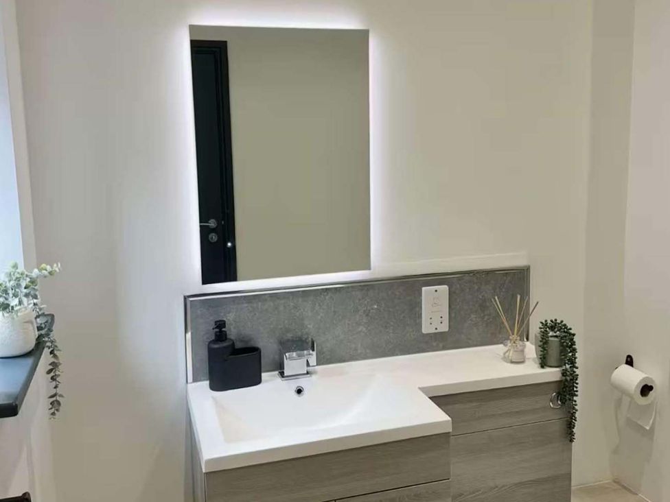 A bathroom with sink, mirror, and decorative elements at New Cosy Retreat in Matlock Bath
