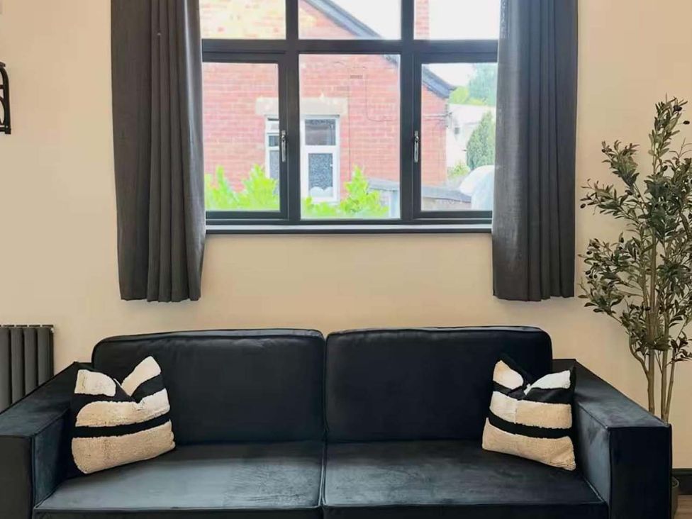A living room with a sofa and window at New Cosy Retreat in Matlock Bath