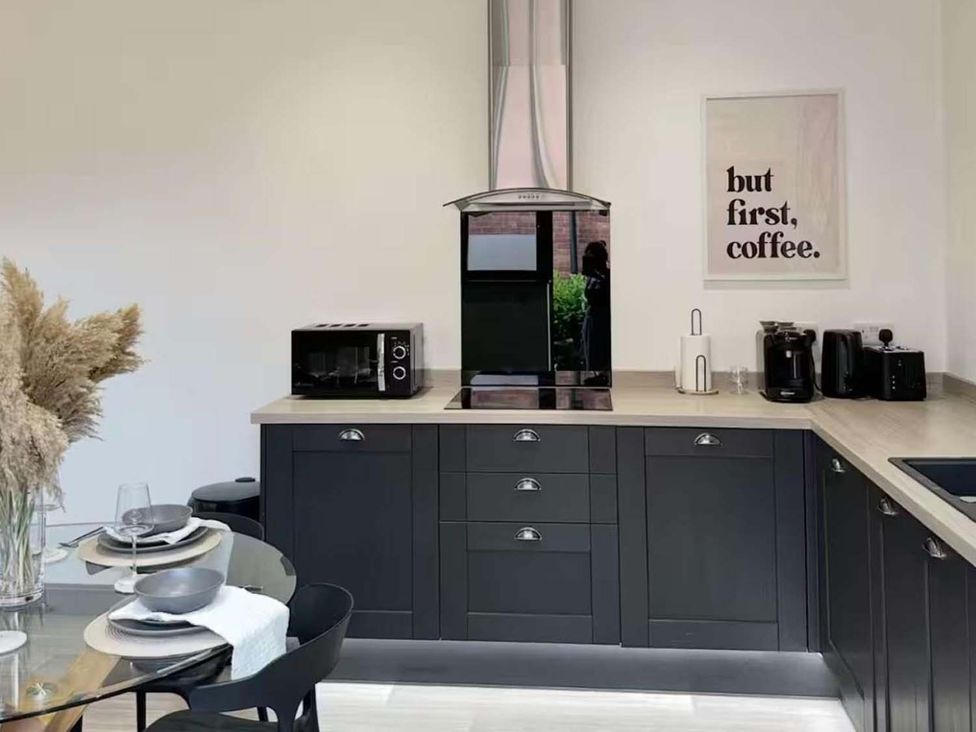 A kitchen with modern appliances and a dining area at New Cosy Retreat in Matlock Bath