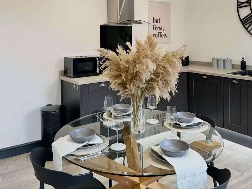 A kitchen with a glass table and chairs at New Cosy Retreat in Matlock Bath