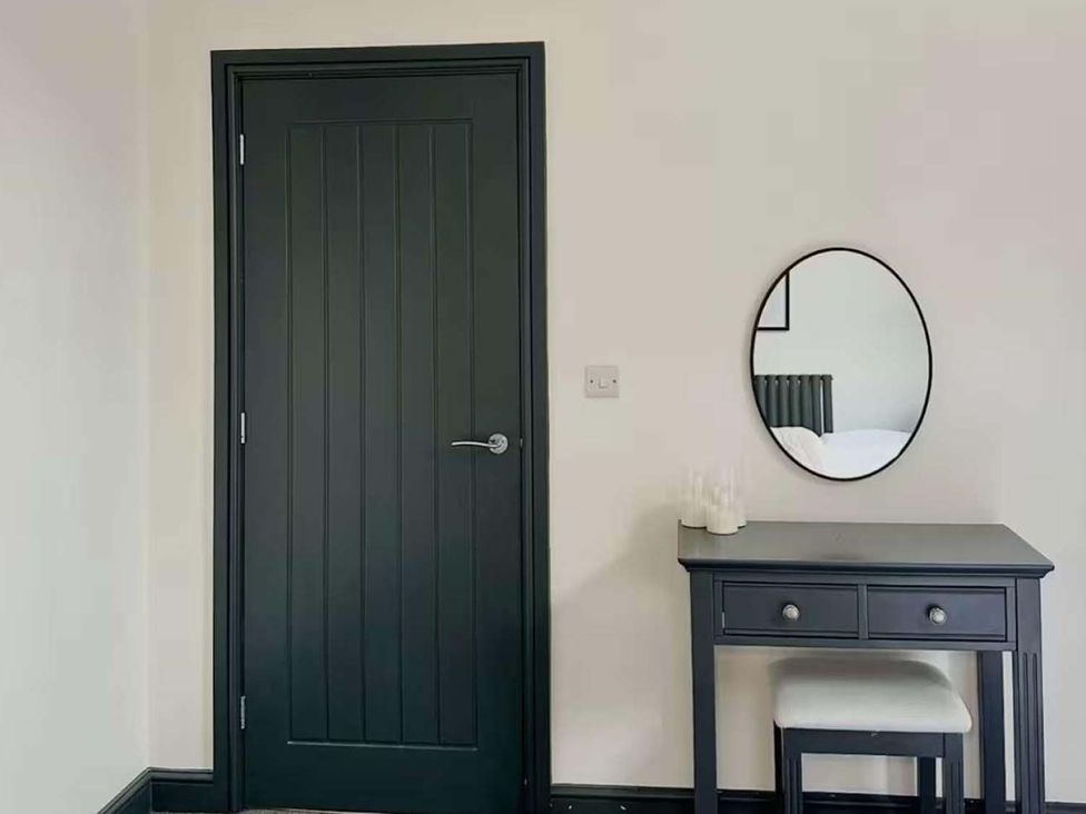 A bedroom with a mirror and a vanity table at New Cosy Retreat in Matlock Bath
