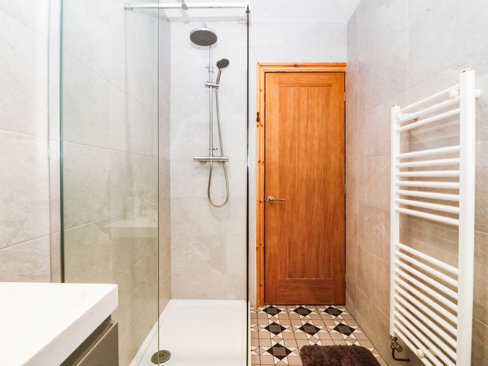 A bathroom with a shower and sink at Derwen-Las in Penmaenmawr