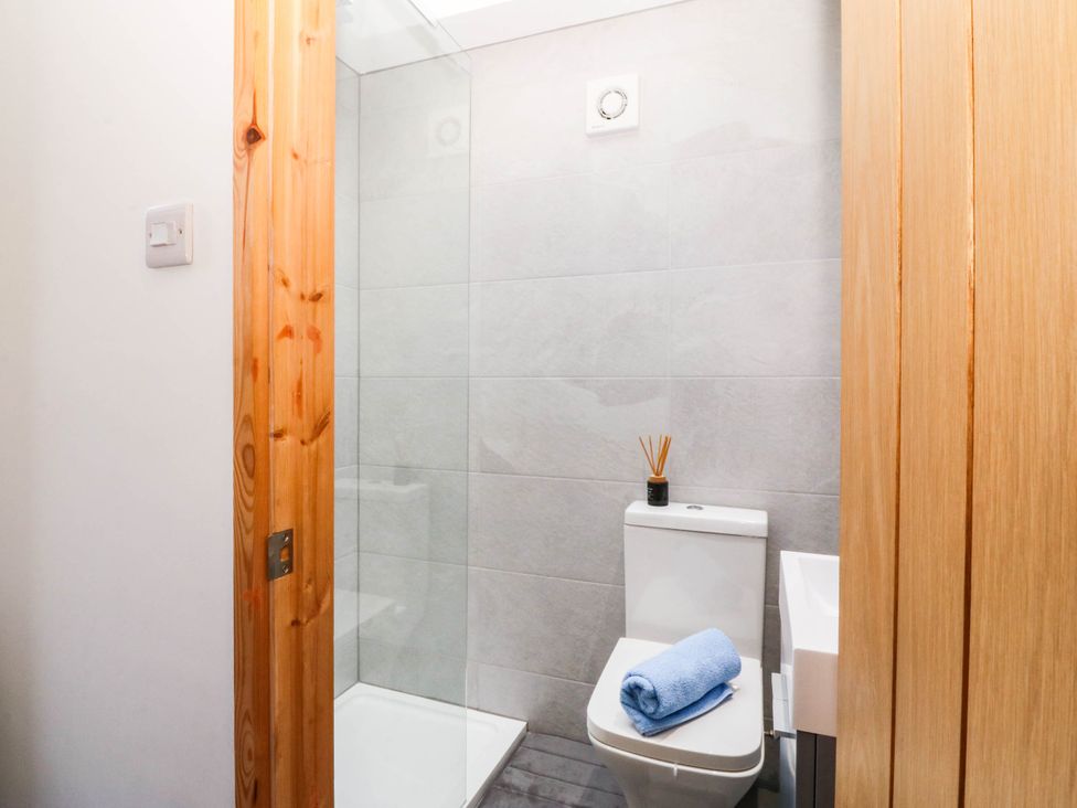 A bathroom with a shower and toilet at Derwen-Las in Penmaenmawr
